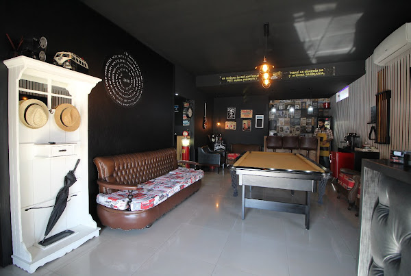 Ambiente da 5ª Avenida Barbearia, com sofás e mesa de sinuca