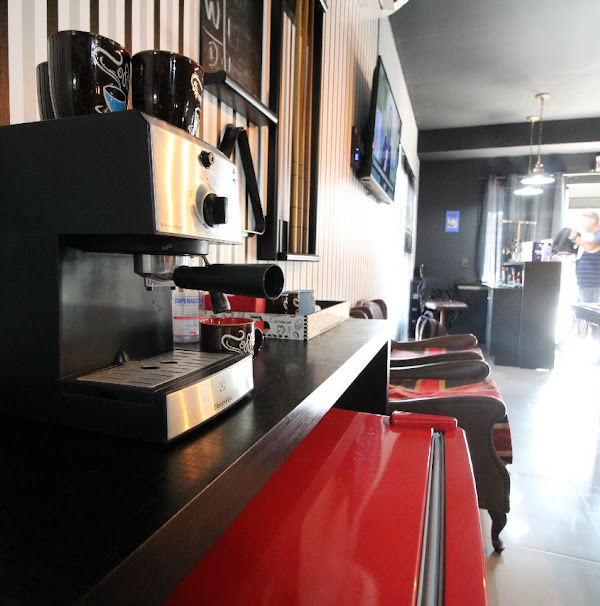 Detalhes do ambiente da 5ª Avenida, com máquina de café e cadeiras